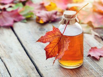 Jar of maple syrup and a leaf